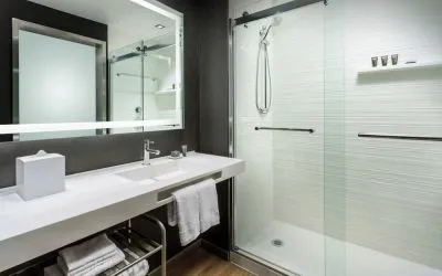 Guest bathroom with shower at AC Hotel By Marriott SFO/Oyster Point Waterfront.