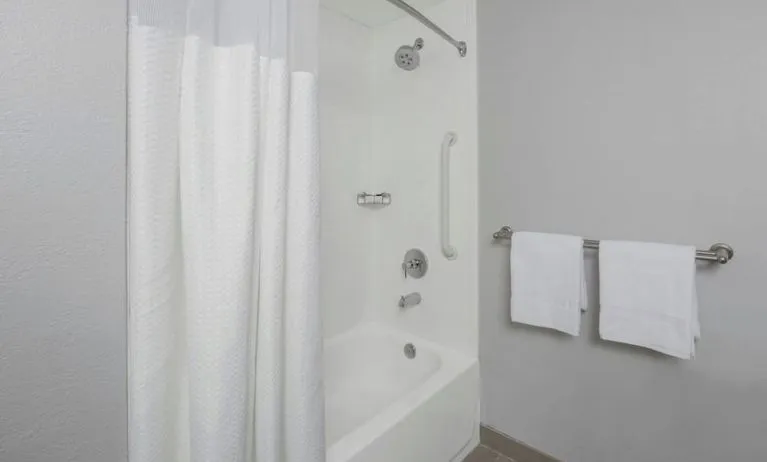 Guest bathroom with shower and tub at Courtyard By Marriott Tampa Oldsmar.