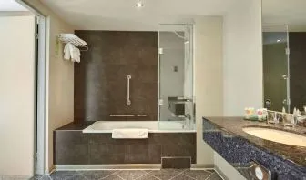 Guest bathroom with combined tub and shower at Hyatt Place London Heathrow Airport. 