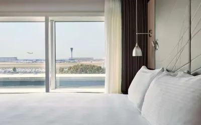 King bed with floor to ceiling window at Hyatt Place London Heathrow Airport.