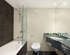 Private guest bathroom with combined tub/shower and free toiletries at Hyatt Place London Heathrow Airport.