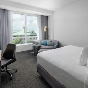 Day use room with sofa and work desk at Courtyard Delray Beach.
