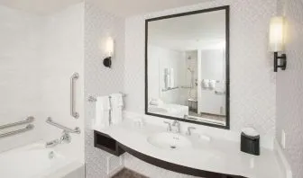 Guest bathroom with shower and tub at Hilton Garden Inn Burbank Downtown.