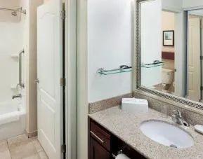 Guest bathroom with shower and tub at Residence Inn By Marriott Hattiesburg.
