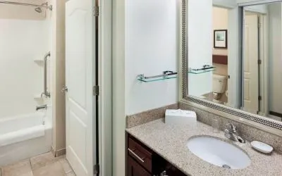 Guest bathroom with shower and tub at Residence Inn By Marriott Hattiesburg.