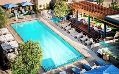 Refreshing outdoor pool surrounded by pool chairs at Hotel Nia, Autograph Collection.