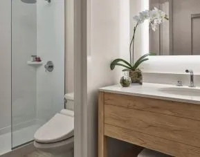Guest bathroom with shower at Alohilani Resort Waikiki Beach.