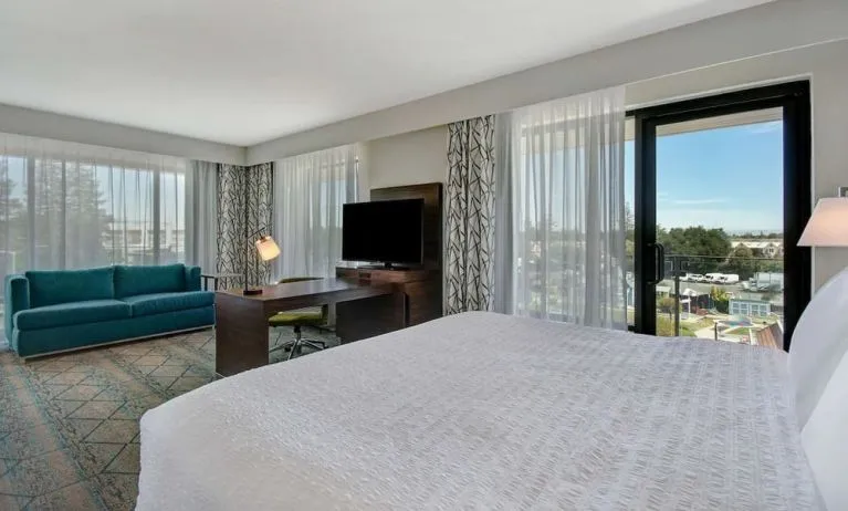 Day use room with work desk, sofa and balcony at Hampton Inn & Suites Sunnyvale Silicon Valley.