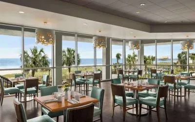 Dining area with natural light perfect for coworking at Embassy Suites By Hilton Myrtle Beach Oceanfront Resort.