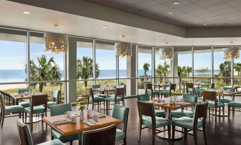 Dining area with natural light perfect for coworking at Embassy Suites By Hilton Myrtle Beach Oceanfront Resort.