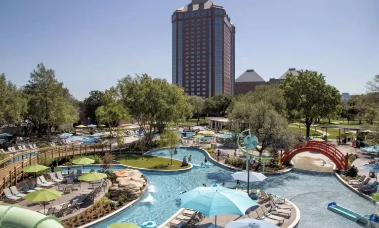 Lazy river, waterslide, and sun loungers available around the outdoor pool at Hilton Anatole.