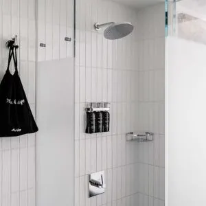 Private guest bathroom with shower and free toiletries at Arlo SoHo.