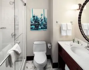 Private guest bathroom with shower and free toiletries at Hilton Brooklyn New York.