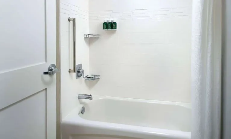 Private guest bathroom with tub and free toiletries at Sonesta ES Suites Raleigh Cary.