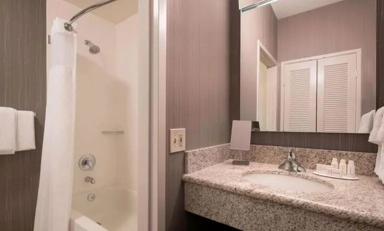 Private guest bathroom with shower and free toiletries at Sonesta Select Tempe Downtown.
