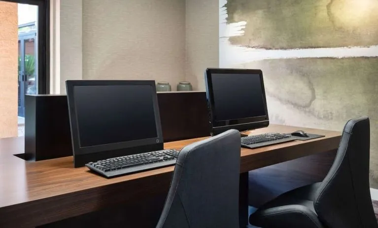Business center with computers and ergonomic chairs at Sonesta Select Phoenix Camelback.