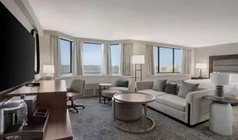 Beautiful king suite with work desk, TV, and sofa at Hilton Crystal City At Washington Reagan National Airport.