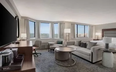 Beautiful king suite with work desk, TV, and sofa at Hilton Crystal City At Washington Reagan National Airport.