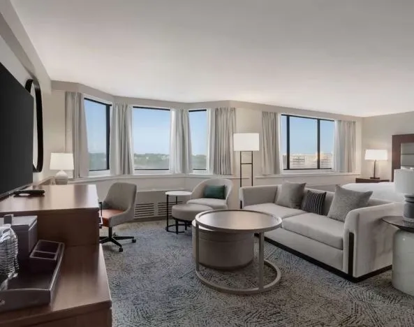 Beautiful king suite with work desk, TV, and sofa at Hilton Crystal City At Washington Reagan National Airport.