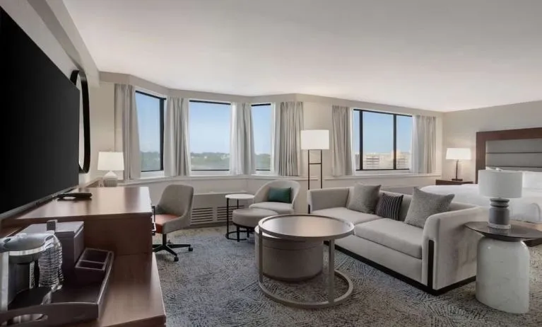 Beautiful king suite with work desk, TV, and sofa at Hilton Crystal City At Washington Reagan National Airport.