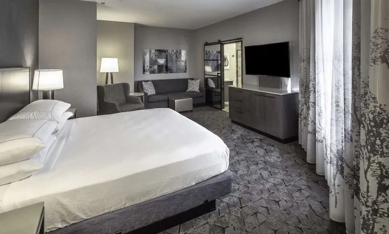 King size bed and sofa in a day use room at DoubleTree By Hilton Modesto.