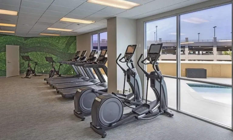 Fitness center with a view of the pool at DoubleTree By Hilton Modesto.