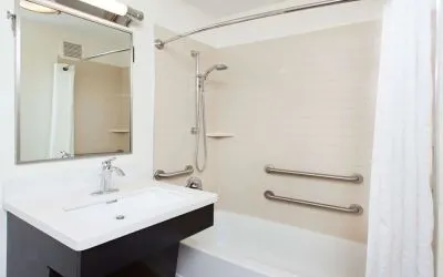 Private guest bathroom with combined shower and tub at Sonesta Simply Suites Dallas Las Colinas.