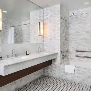 Private guest bathroom with combined shower and tub at Nautilus Sonesta Miami Beach.