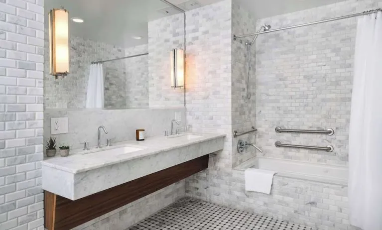 Private guest bathroom with combined shower and tub at Nautilus Sonesta Miami Beach.