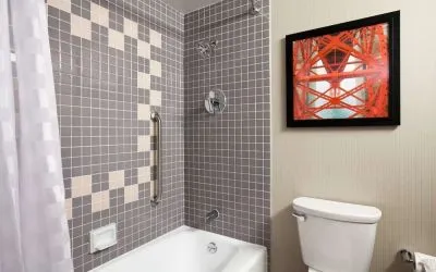 Guest bathroom with shower and tub at Embassy Suites By Hilton San Francisco Airport Waterfront.