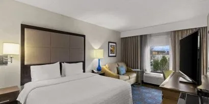 Comfortable king room with sofa and work desk at Hampton Inn Bloomington.