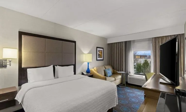Comfortable king room with sofa and work desk at Hampton Inn Bloomington.