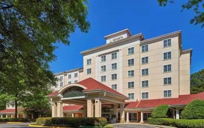 Sonesta Atlanta Airport South’s exterior features a covered entrance, well-kept greenery, and stylish red roof tiles.