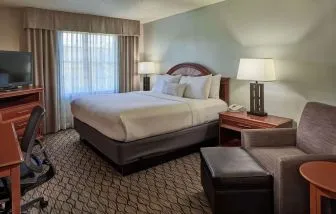 King bed with work desk and lounge seating at Sonesta Atlanta Airport South.