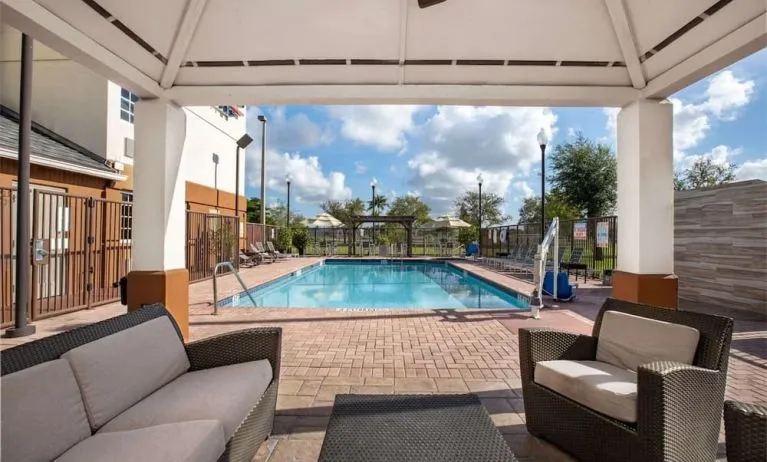 Outdoor pool with lounge area at Sonesta Simply Suites Miami Airport Doral. 