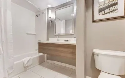 Private guest bathroom with combined shower and tub at Sonesta Anaheim Resort Area.
