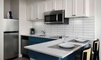 In-room kitchen, equipped with microwave, fridge, sink and breakfast bar at Sonesta ES Suites Chicago Downtown Magnificent Mile - Medical.