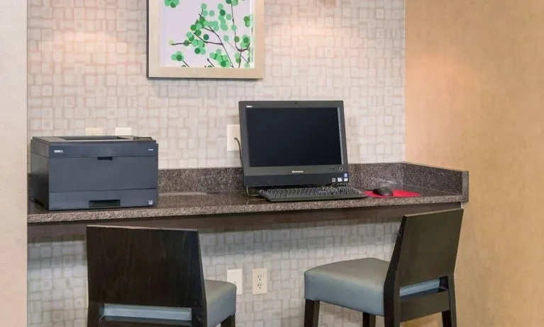 Business center with computer, printer and comfortable chairs at Sonesta ES Suites Charlottesville University.