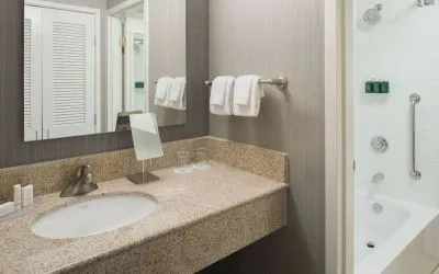 Private guest bathroom with combined shower/tub and free toiletries at Sonesta Select Seattle Bellevue Redmond.