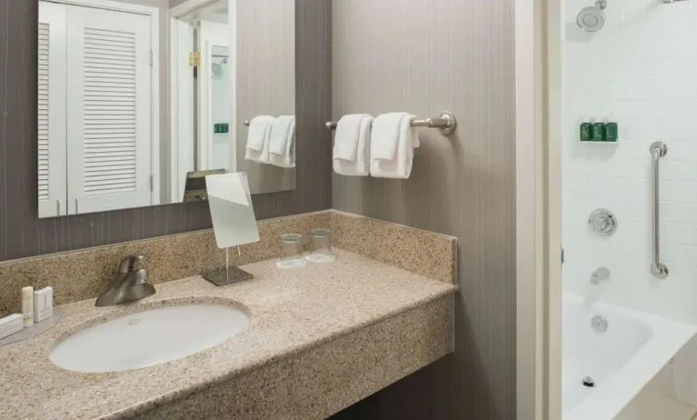 Private guest bathroom with combined shower/tub and free toiletries at Sonesta Select Seattle Bellevue Redmond.