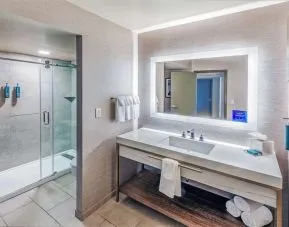 Guest bathroom with shower at DoubleTree By Hilton Tulsa-Downtown.
