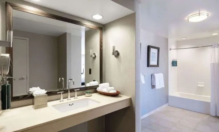 Guest bathroom with shower and tub at Hilton San Francisco Financial District.