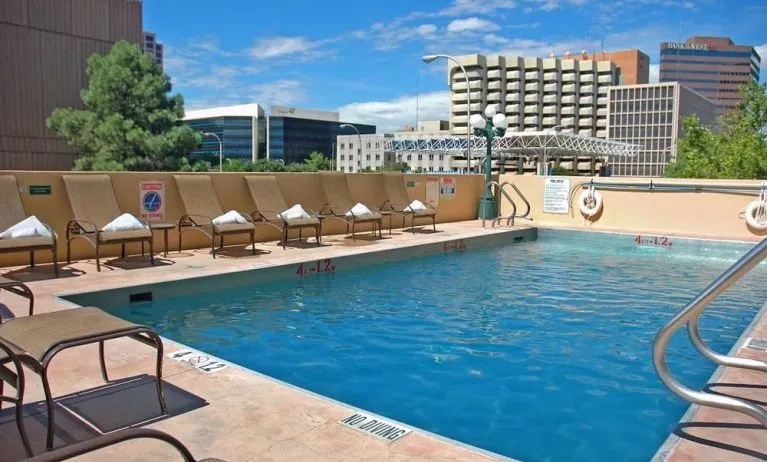Refreshing outdoor pool surrounded by sunbeds at DoubleTree By Hilton Albuquerque.