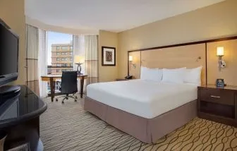 Spacious king room with TV and work area ideal for working remotely at Hilton Rosemont/Chicago O'Hare.