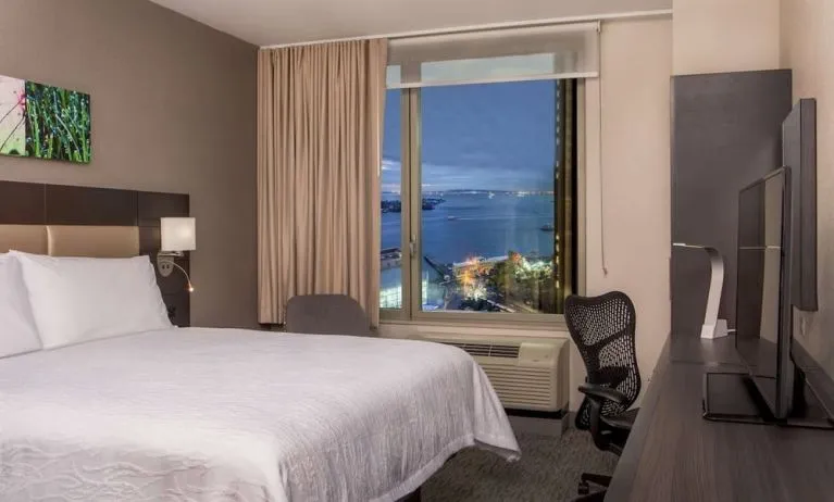 King bedroom with work station and city view at Hilton Garden Inn NYC Financial Center/Manhattan Downtown.
