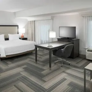 King bed with work desk and living area at Hampton Inn & Suites By Hilton Atlanta Perimeter Dunwoody.