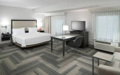 King bed with work desk and living area at Hampton Inn & Suites By Hilton Atlanta Perimeter Dunwoody.