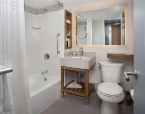Private guest bathroom with combined shower and tub at New York Hilton Midtown.