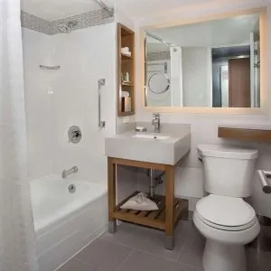 Private guest bathroom with combined shower and tub at New York Hilton Midtown.