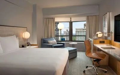 King room with work desk and sofa at New York Hilton Midtown.